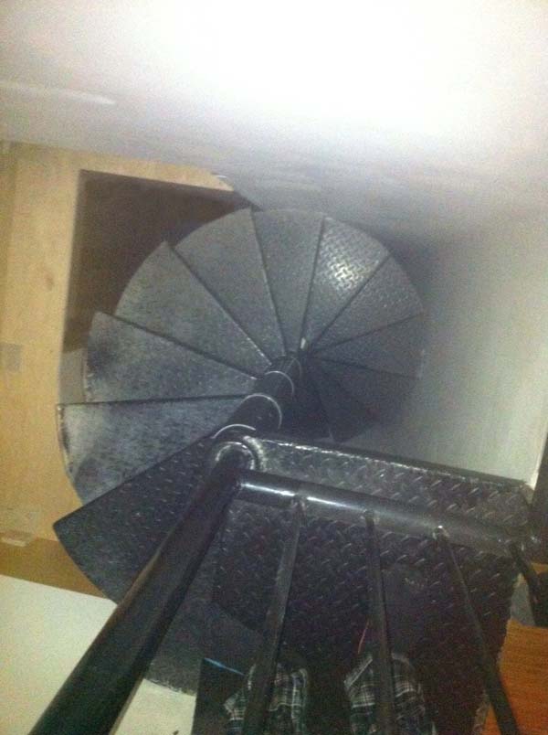 The tall, spiral staircase seemed to lead downward directly into a wall.