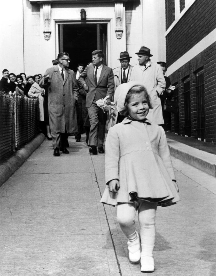 Caroline Kennedy walks ahead while her father, the most powerful man in the world, carries her doll. (1960).