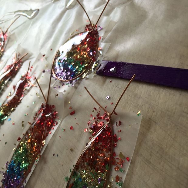 Use a popsicle stick or plastic spoon and load your wire frames with the resin.