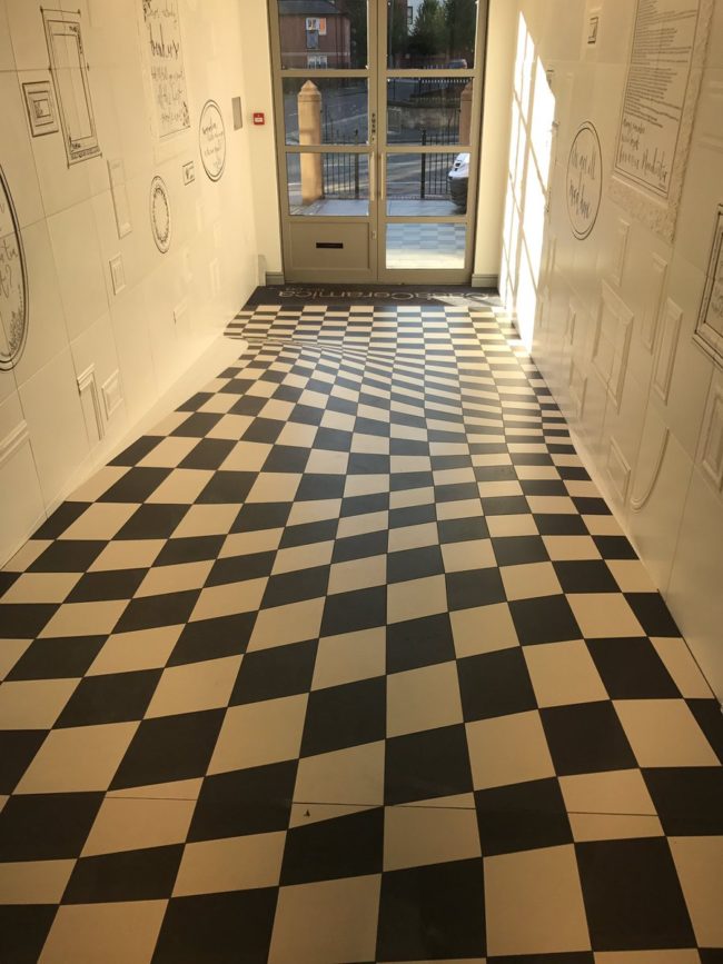 If you can believe it, this was designed so that the hallway would look totally normal to anyone entering or looking through that glass door.