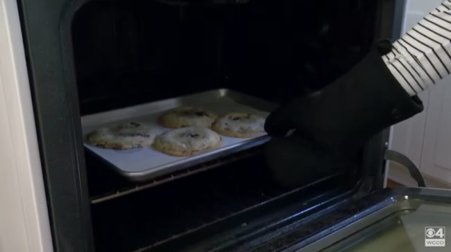 When the 10 minutes are up, Kieffer opens up the oven and bangers her cookie sheet against the wire rack of the oven. This technique, which she calls "panbanging" helps create beautiful ripples in her cookies, leaving them flattened.