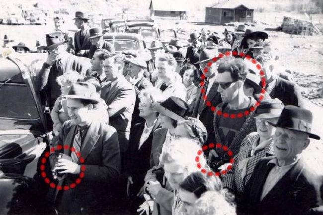 The Time Traveler: People believe that this photograph, taken in 1941 at the re-opening of the South Forks Bridge in Gold Bridge, Canada, is depicting a man in seemingly modern dress and style, with a camera that is advanced well beyond its time. The circle on the left illustrates a man with a camera typical to the time-period.