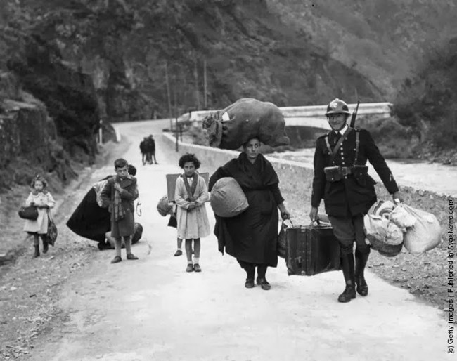 A French soldier helps a family flee danger during the Spanish Civil War in 1938.