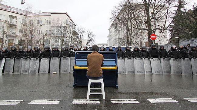 A man plays the piano for riot police in Kiev, Ukraine in 2013.