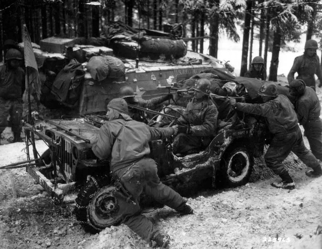 American soldiers push a car carrying two severely wounded German soldiers, 1945.