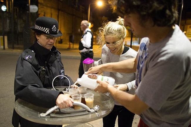 Protestors offer tea to riot police in London in 2011.