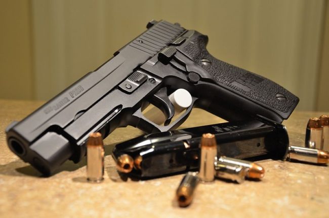 A search around the apartment yielded a box of ammunition on top of the refrigerator and a makeup bag filled with baggies of white and pink powder, which tested positive for Oxycodone.