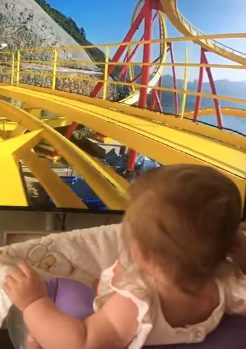 At first glance, it looks like Holly is on a real roller coaster, but she's actually just in front of her parents' TV.